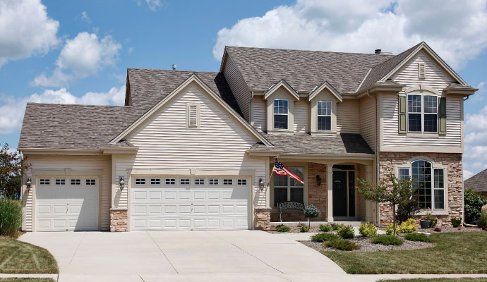 A modern residential house featuring two white garage doors