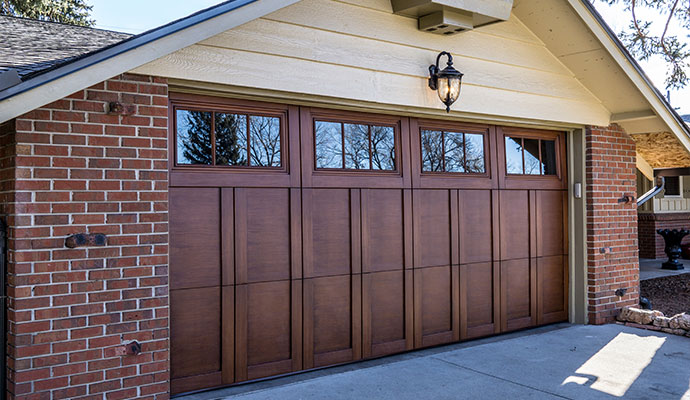 Stained wood panel garage door with windows