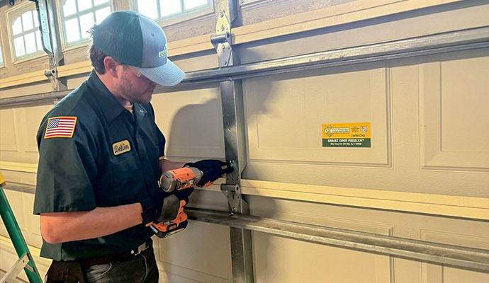 Technician tightening hardware on garage door panel