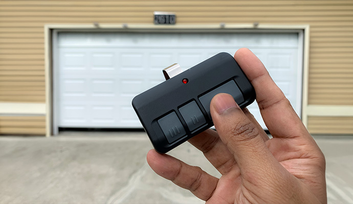 User holding three button garage door visor remote