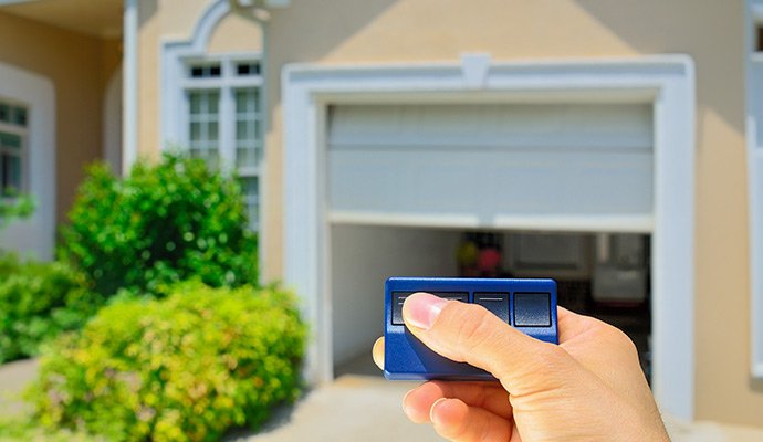 User pressing remote to open residential garage door