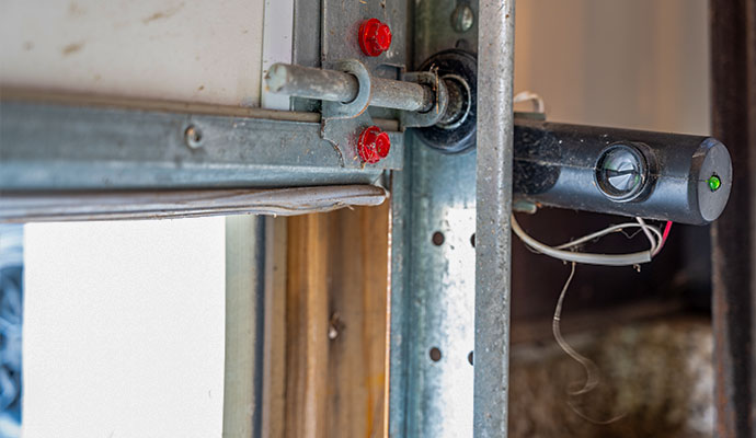 Damaged garage door safety sensor with exposed wiring