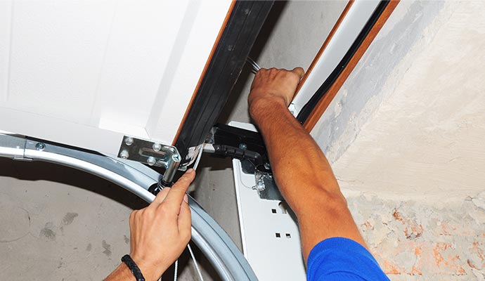 Professional technician repairing a damaged garage door roller