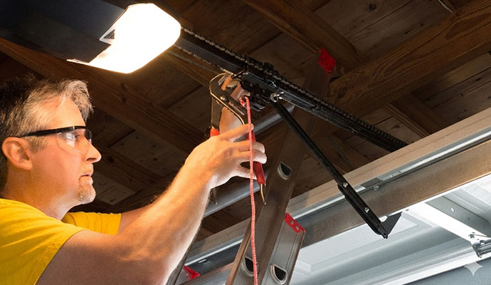 Technician adjusting garage door opener chain drive