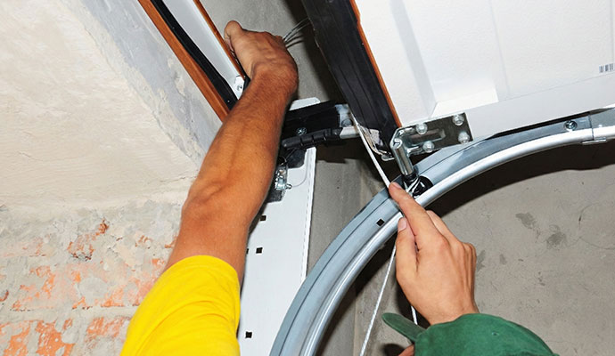 Technician repairing garage door lift cable