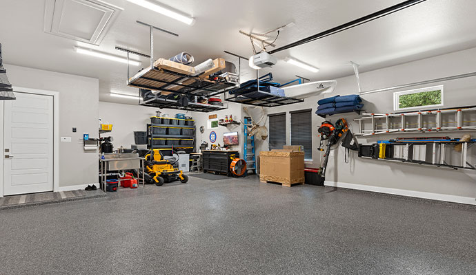 Garage with ceiling-mounted hanging storage racks for organizing tools and seasonal items