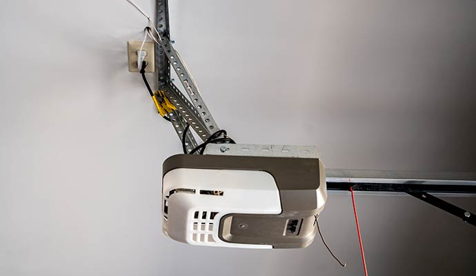 Motorized garage door opener mounted on the ceiling